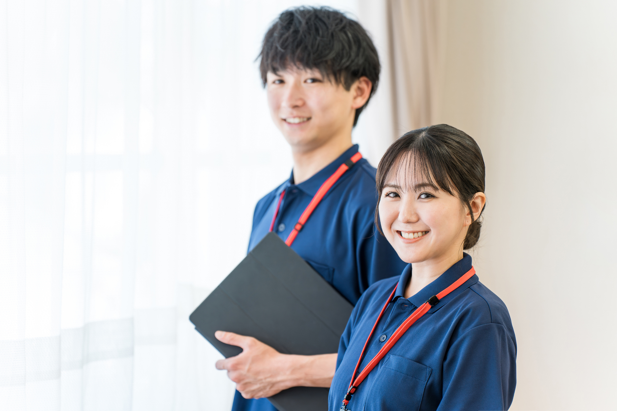 クリップボードを持って並ぶ男女の介護職員