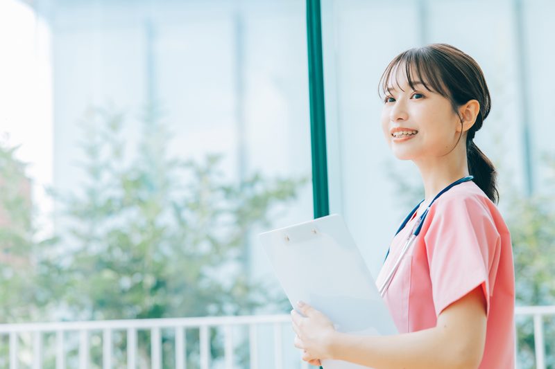 書類を手に笑顔で前を向く介護職員