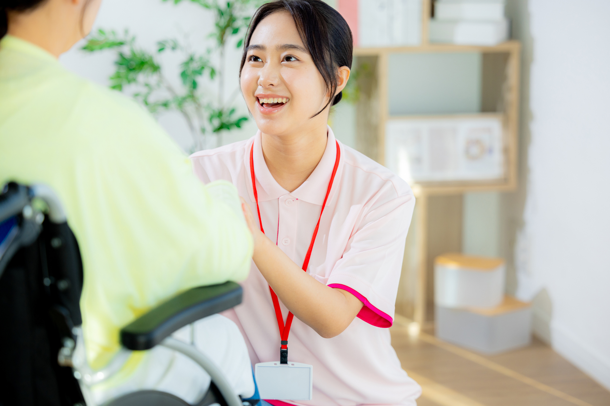 車いすの利用者に笑顔で声をかける介護職員
