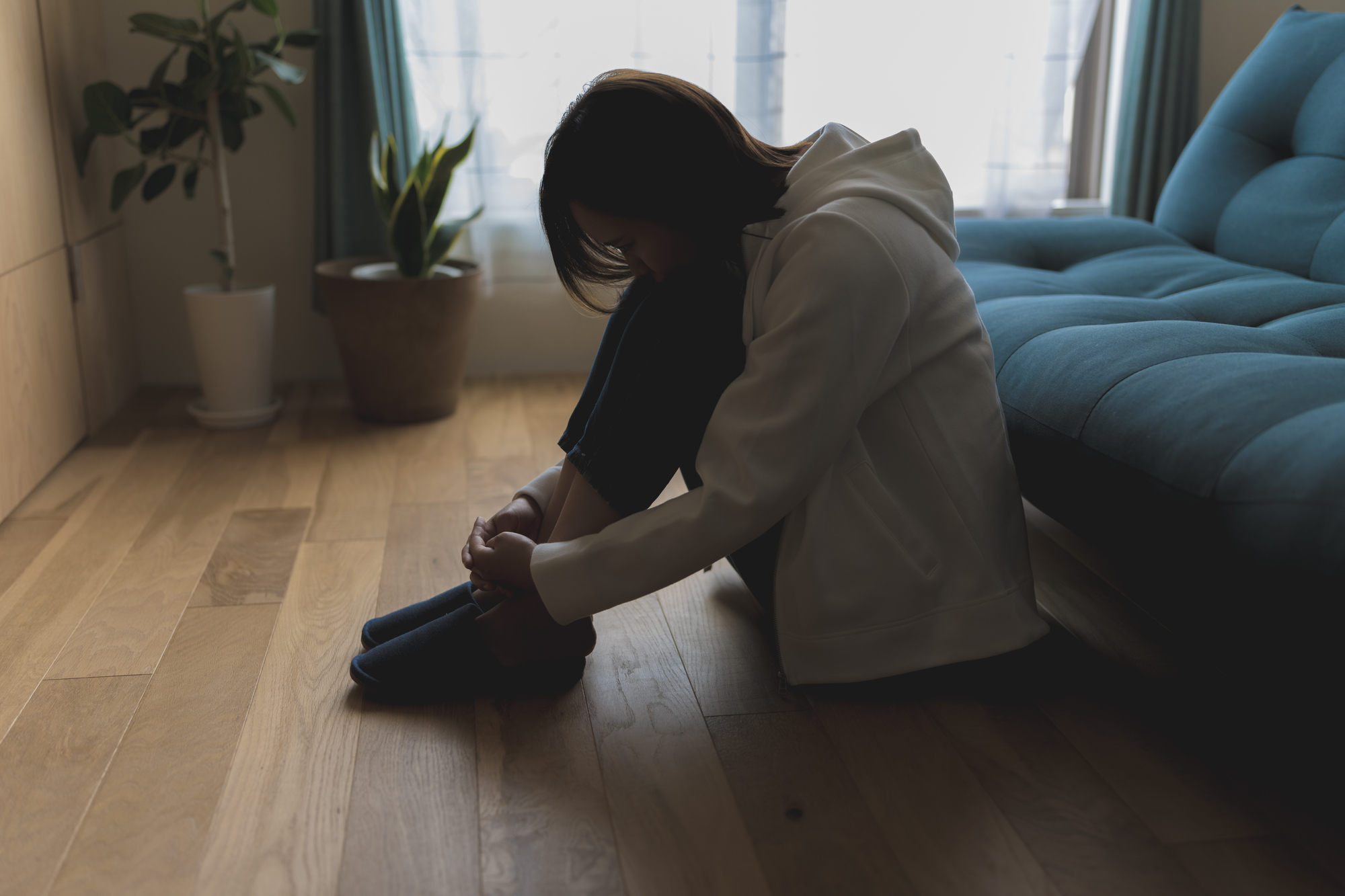 部屋の隅で膝を抱えて落ち込む人