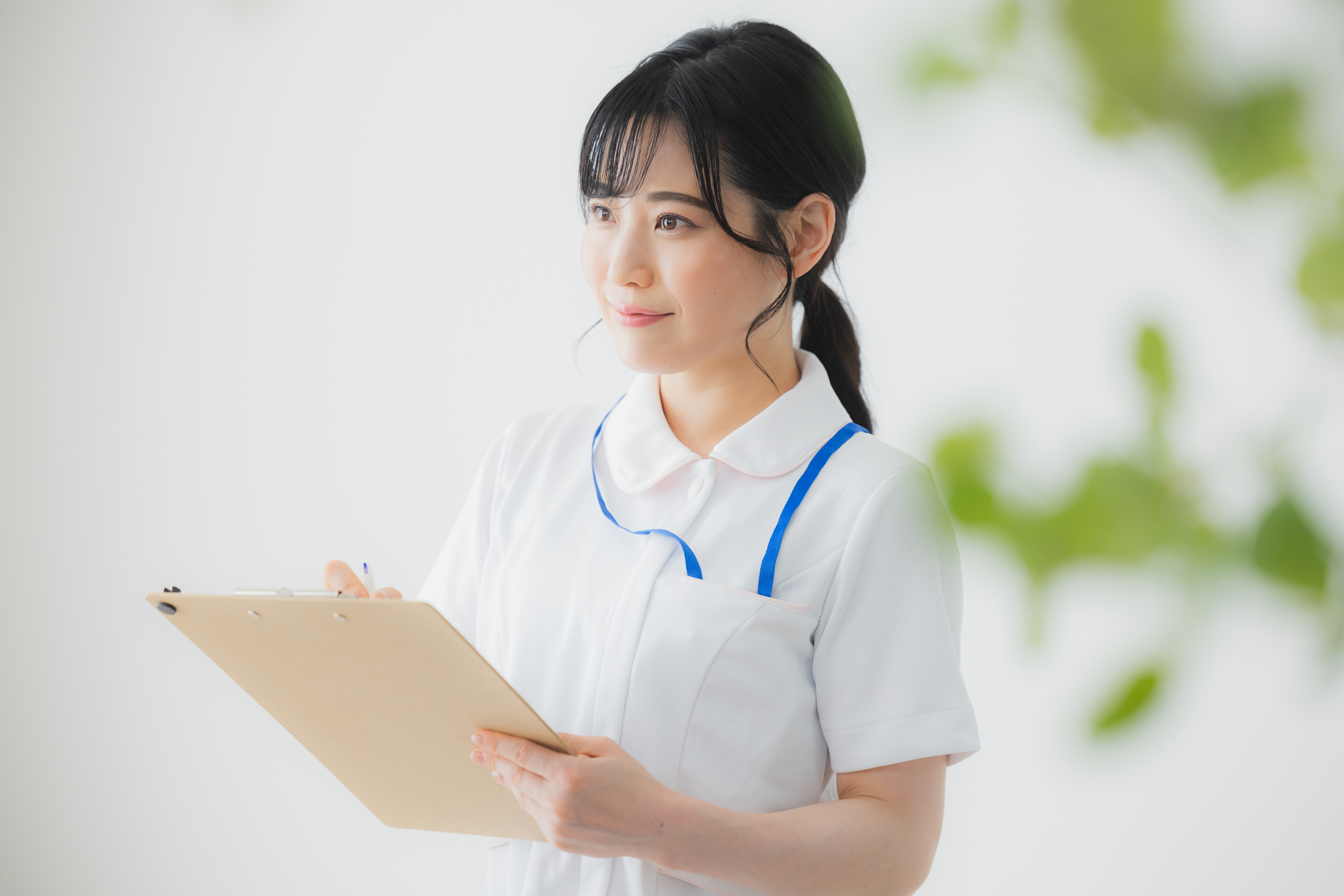 クリップボードを手に利用者の様子を見守る看護師